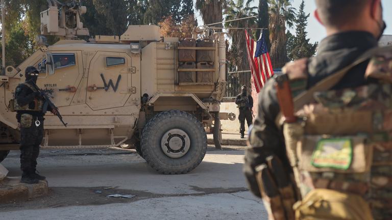 Kämpfer der Syrischen Demokratischen Kräfte (SDF) stehen in der Nähe eines US-Militärfahrzeugs der US-geführten Koalition gegen die Gruppe Islamischer Staat in Deir Hafer. 