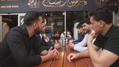 Gruppe syrischer Männer vor einem Restaurant