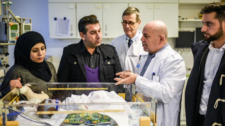 Chefarzt Kinderkardiologie Dr. Aktham Tannous (2.v.r.) aus Syrien am Bett des herzkranken Kindes Yousef Abo Eysa aus Syrien und seine Familie