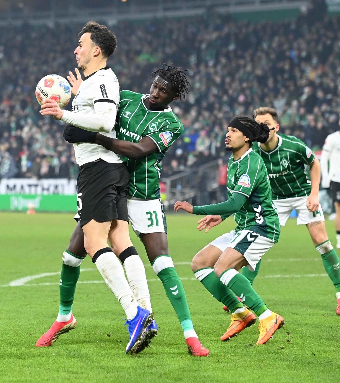 In der Bundesligapartie zwischen dem SV Werder Bremen und Borussia Mönchengladbach versuchen die Bremer Coulibali und Schmidt im Zweikampf Gladbachs Tabakovic den Ball zu entreißen