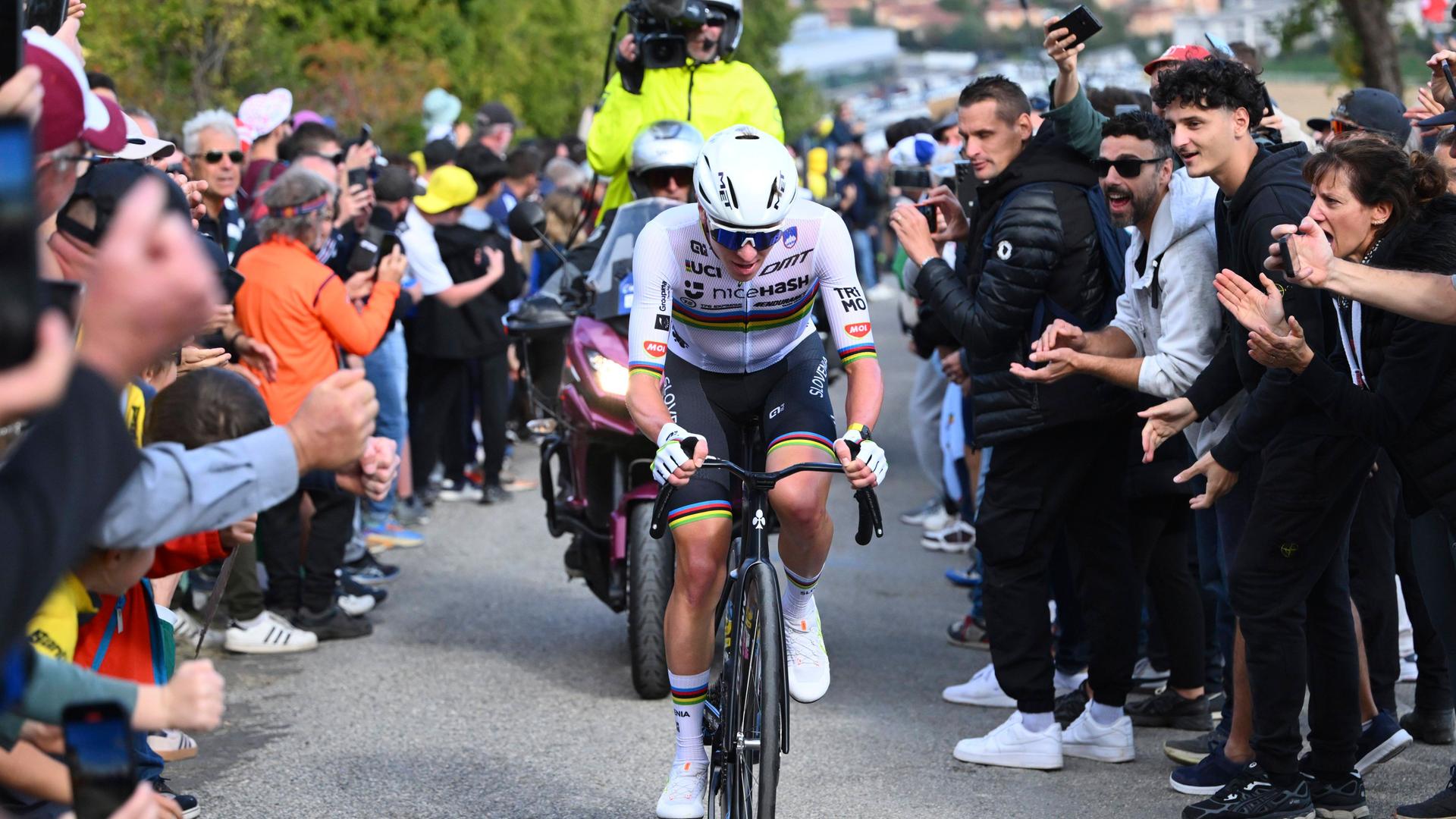 Tadej Pogacar fährt im Straßenrennen der EM einen Berg hoch, Zuschauer applaudieren.
