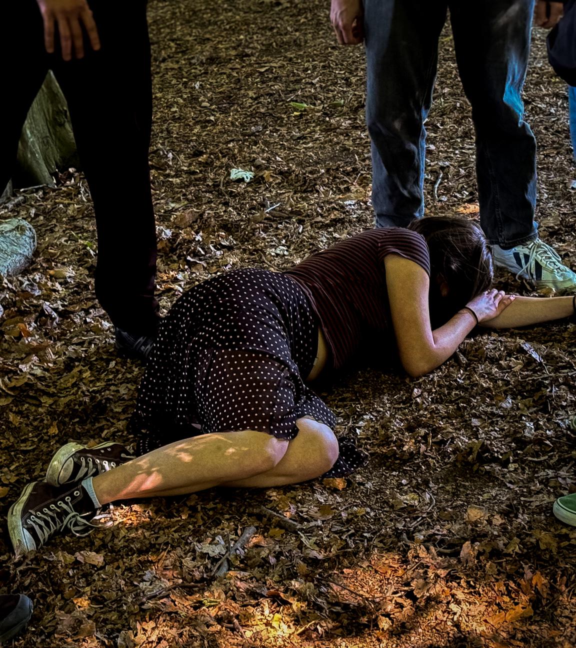 Nachgestellte Szene: Mehrere junge Männer stehen um ein Mädchen herum, das auf dem Boden im Hamburger Stadtpark liegt.