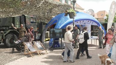 Stand der Bundeswehr und Bundeswehrfahrzeug auf einem Platz