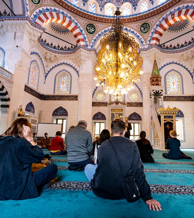 Menschen besuchen die Sehitlik Moschee am Tag der offenen Moschee