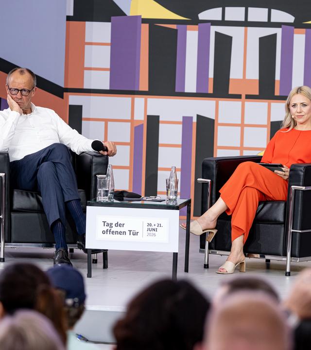 Friedrich Merz (CDU,l) spricht neben Olga Patlan, deutsch-ukrainische Journalistin.