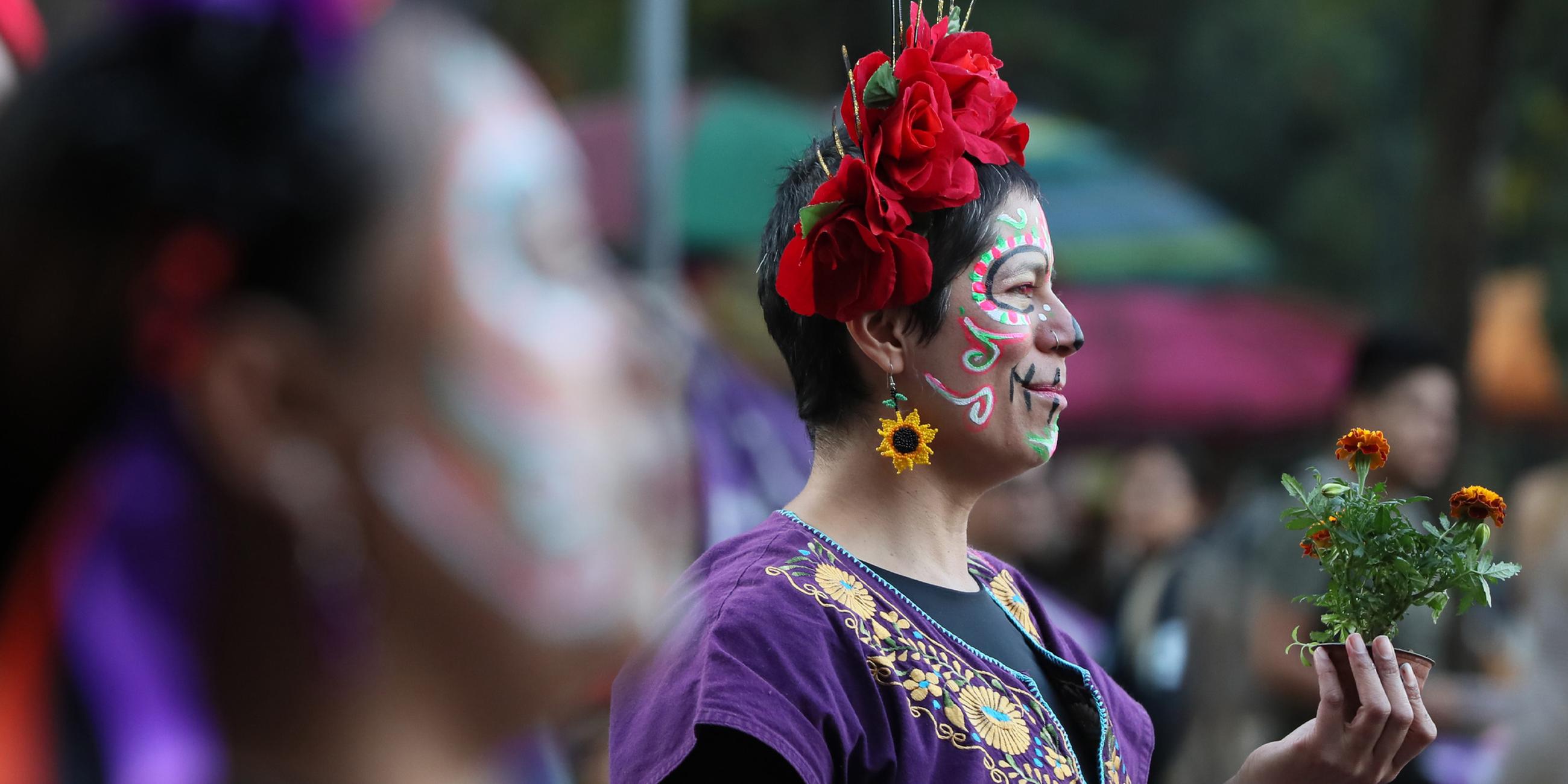 Menschen nehmen während der Feierlichkeiten zum Tag der Toten am 31. Oktober 2025 in Mexiko-Stadt an einem Marsch zur „Antimonumenta“ teil.