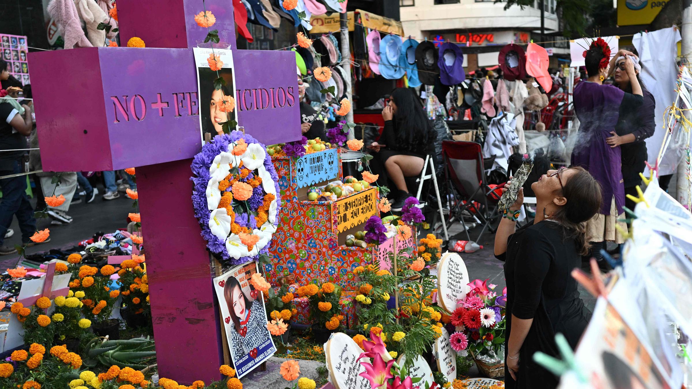 Eine Frau führt ein Ritual am Altar für Opfer von Feminiziden während eines Protestmarsches zur Aufklärung von Feminiziden vor den Feierlichkeiten zum Tag der Toten am 31. Oktober 2025 in Mexiko-Stadt durch.