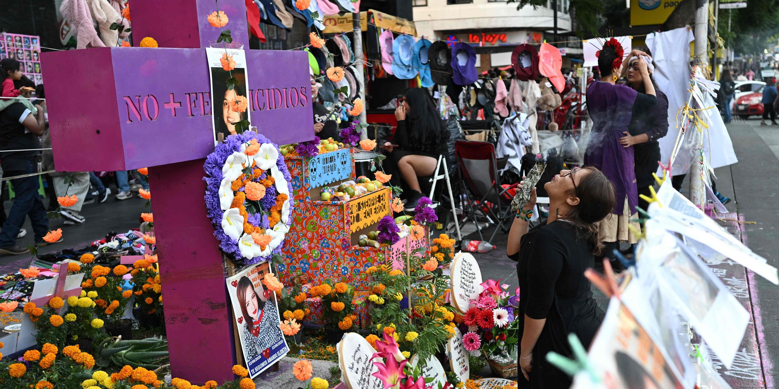 Eine Frau führt ein Ritual am Altar für Opfer von Feminiziden während eines Protestmarsches zur Aufklärung von Feminiziden vor den Feierlichkeiten zum Tag der Toten am 31. Oktober 2025 in Mexiko-Stadt durch.