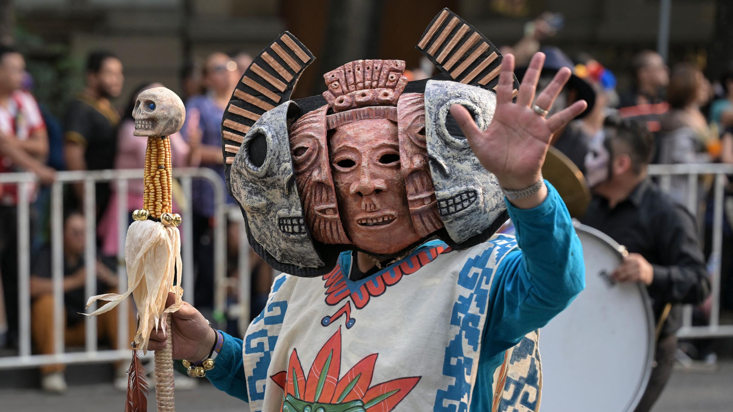 Eine verkleidete Person läuft bei der Parade zum Tag der Toten in Mexiko City.