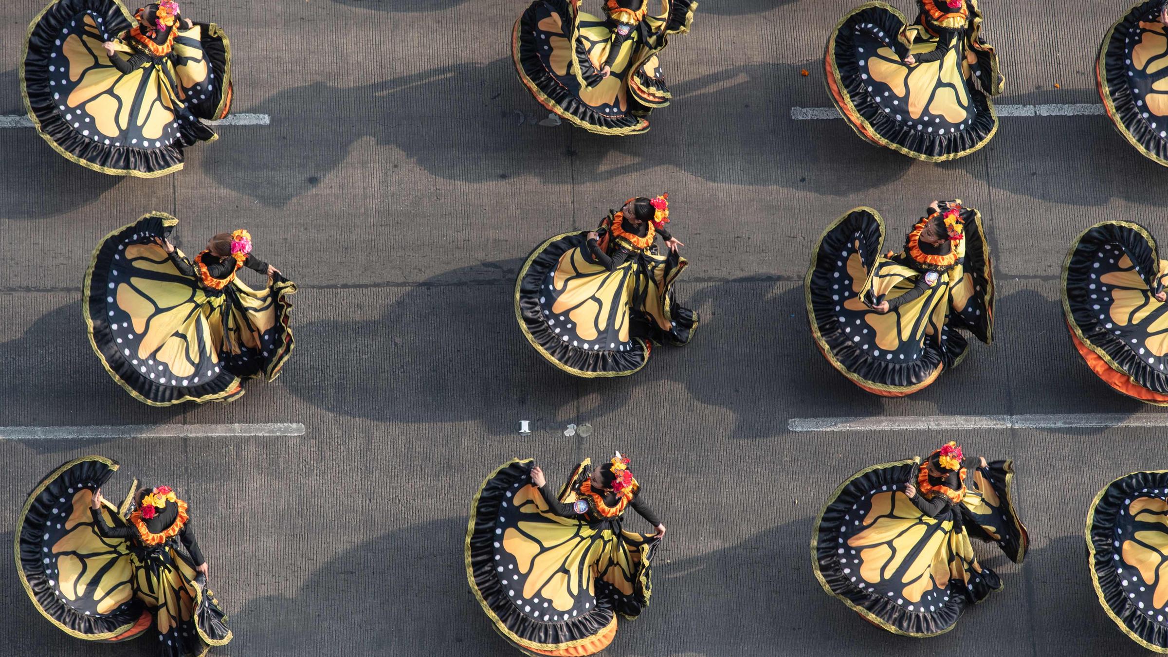 Menschen in Kleidern tanzen bei der Parade zum Tag der Toten in Mexiko City.