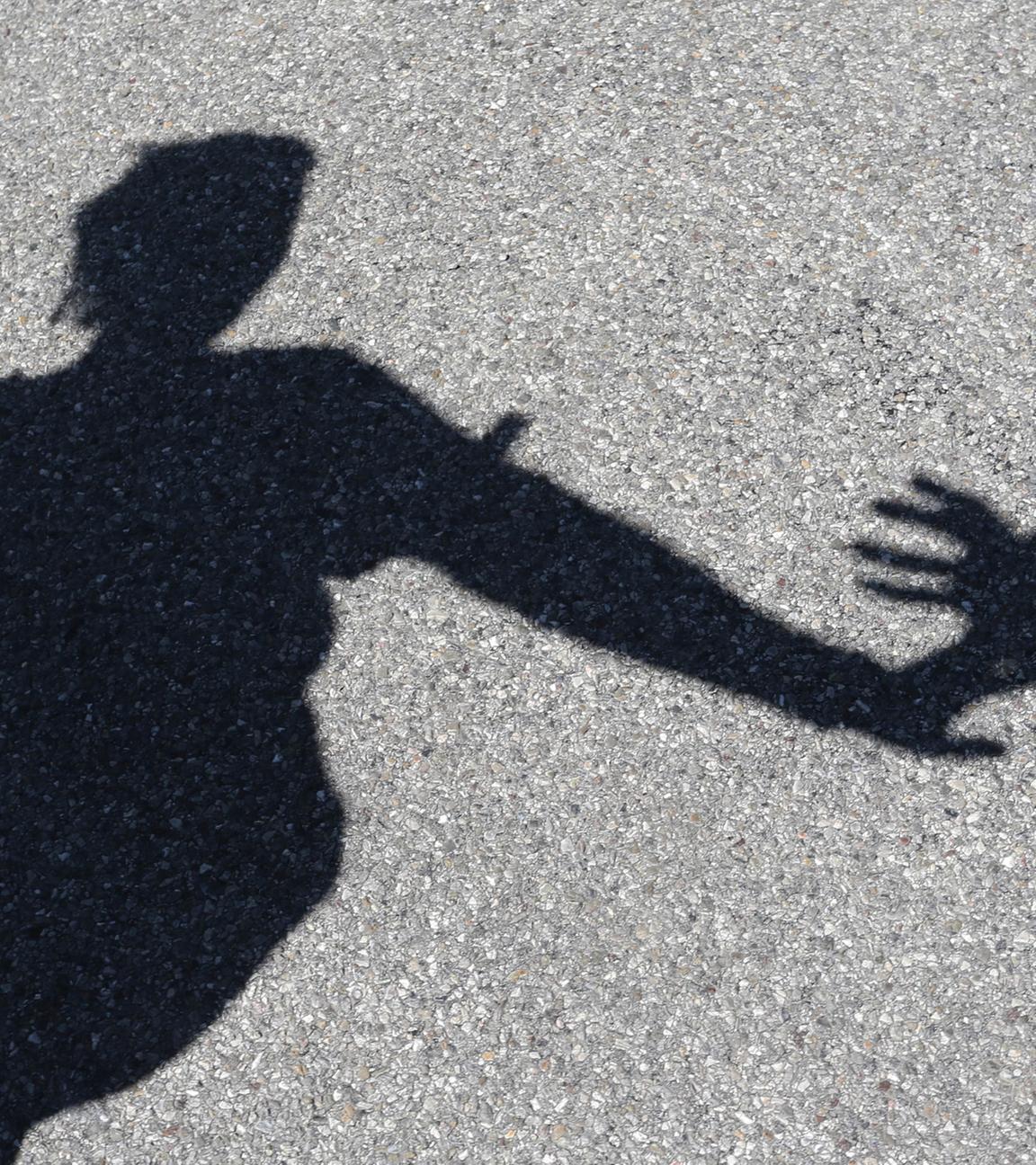 Männlicher Schatten greift nach weiblichem Schatten
