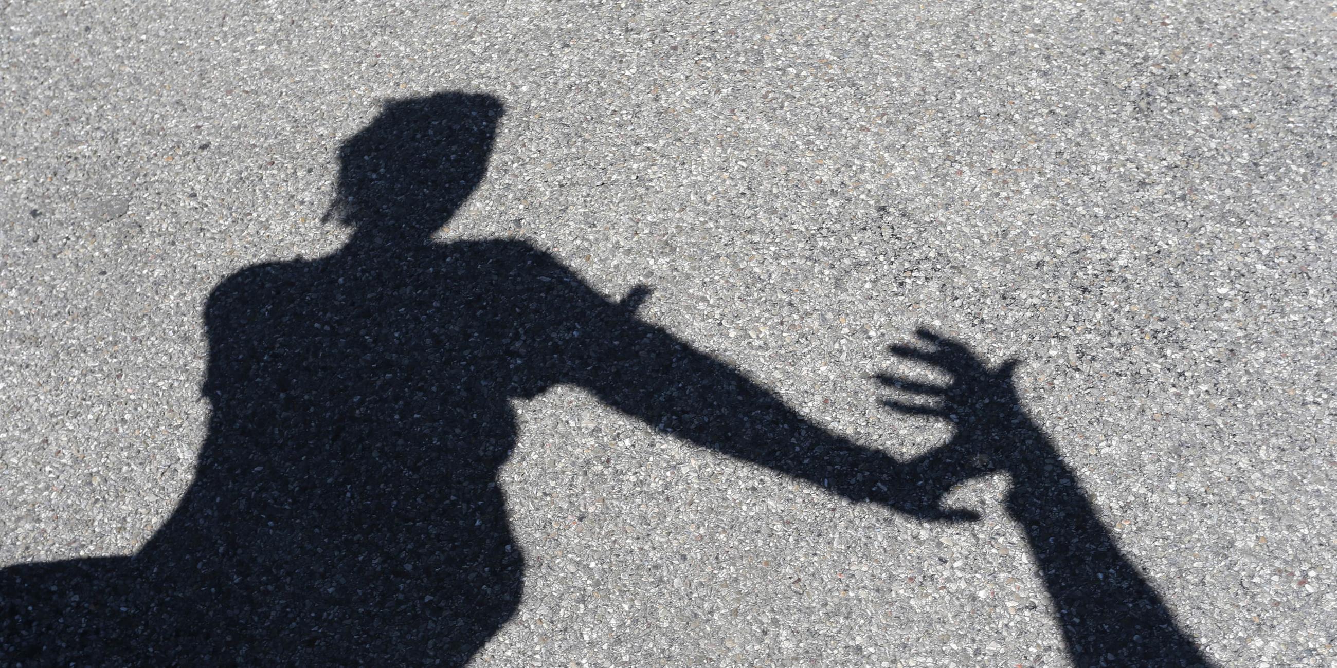 Männlicher Schatten greift nach weiblichem Schatten