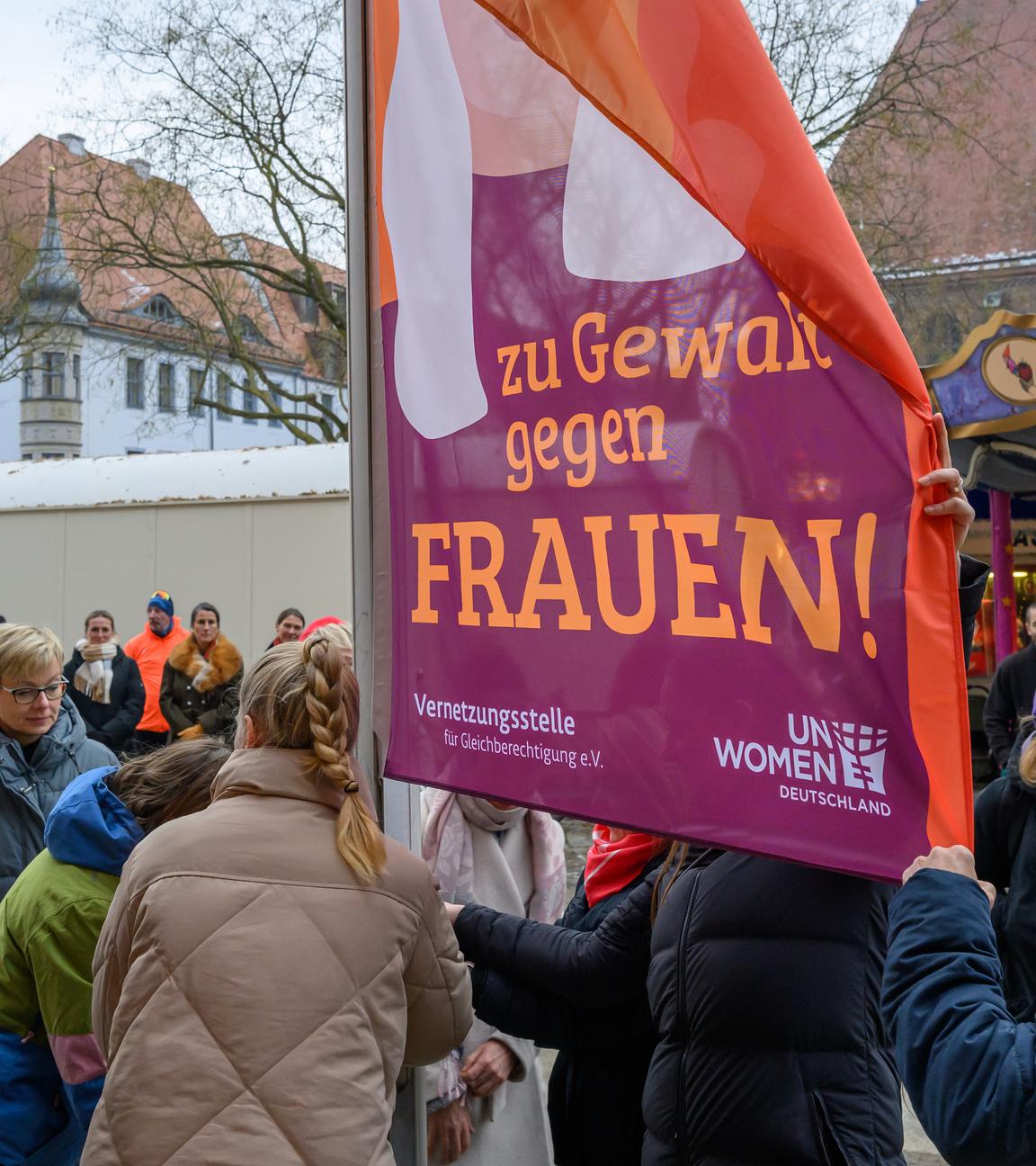 Frauen der Stadt Frankfurt (Oder) hissen die Orange Day Flagge anlässlich einer Kundgebung zum Internationalen Tag zur Beseitigung von Gewalt gegen Frauen.