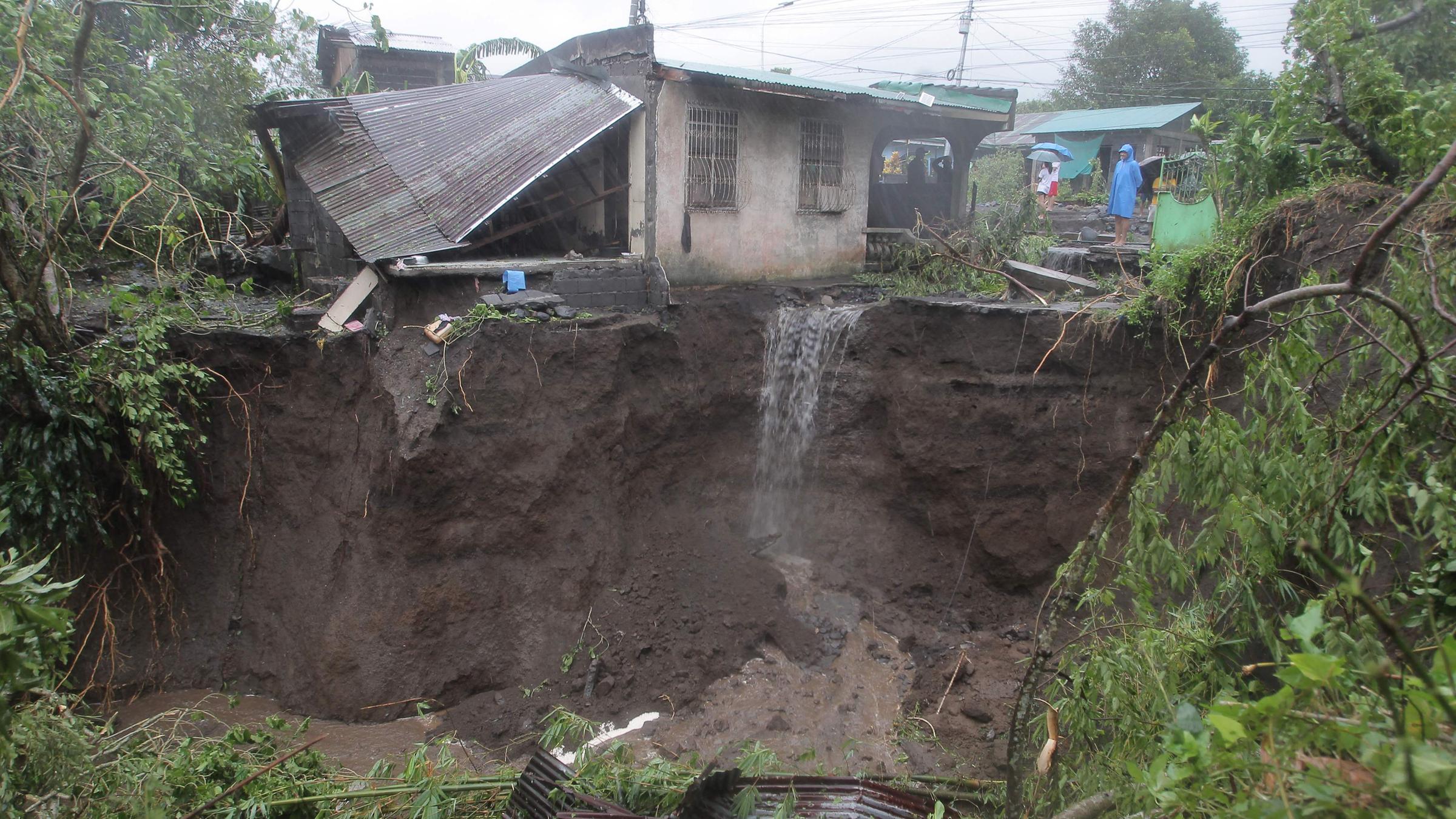 Ein Mann betrachtet am 09.11.2025 ein von einem Erdrutsch betroffenes Wohngebiet in der Stadt Guinobatan in der Provinz Albay südlich von Manila, nachdem der Supertaifun Fung-wong heftige Regenfälle verursacht hatte. 