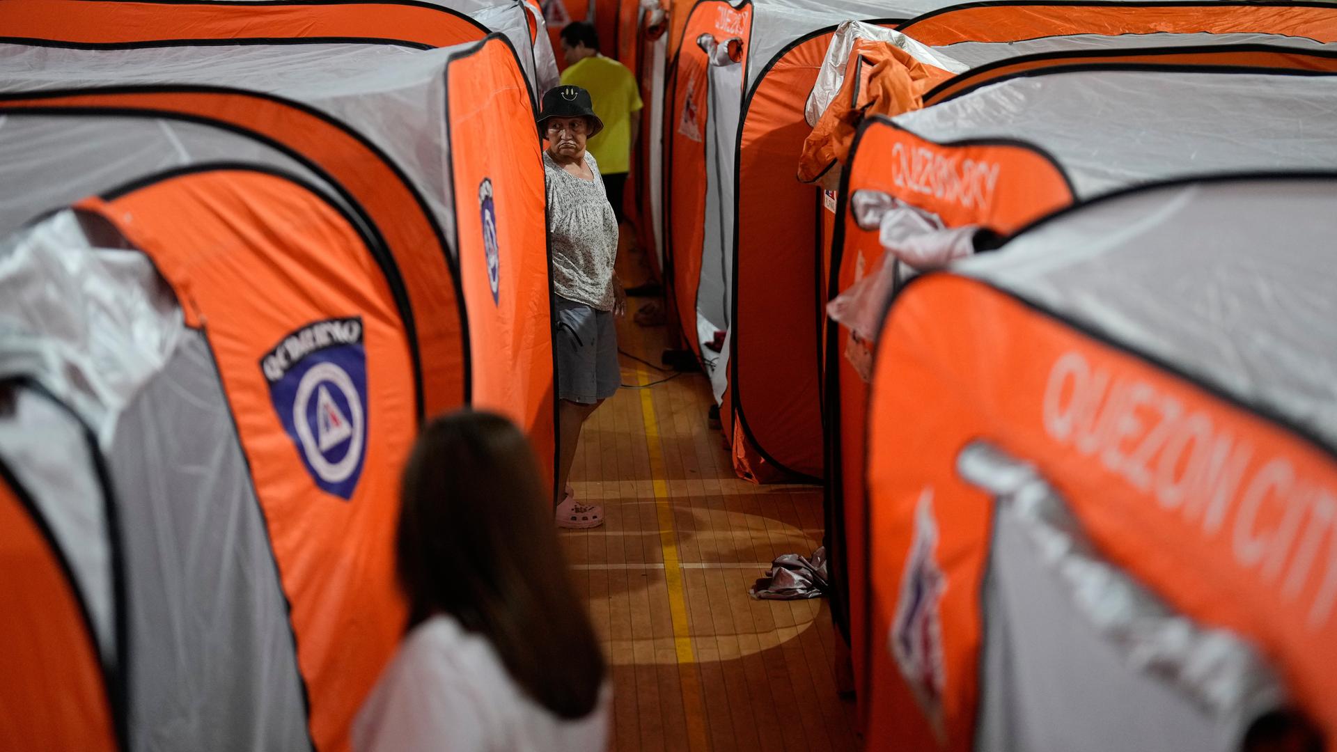 Eine Frau geht an Zelten in einer Notunterkunft vorbei, während der Taifun Fung-wong am 09.11.2025, in Quezon City auf den Philippinen auf Land trifft.