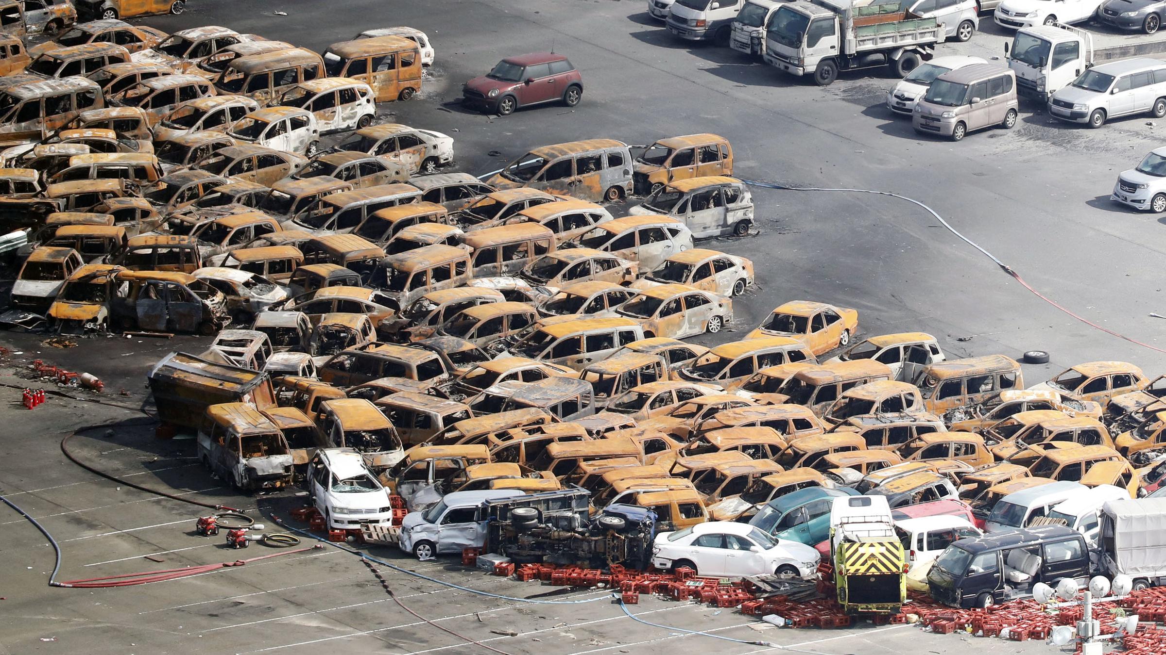 Rauchende Autos wurden auf einem Parkplatz im Westen Japans durch den Taifun ''Jebi'' zusammengeschoben.