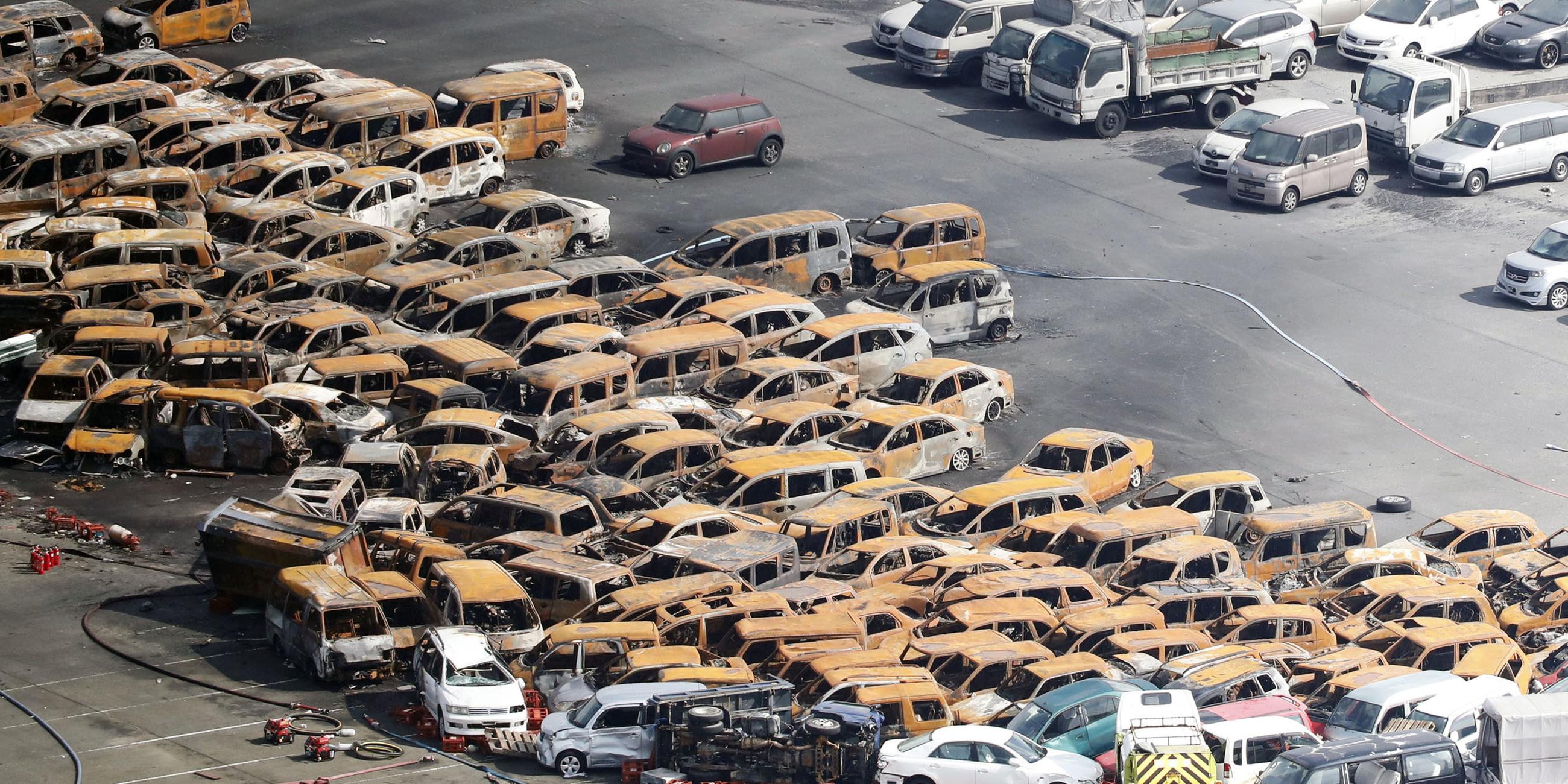 Rauchende Autos wurden auf einem Parkplatz im Westen Japans durch den Taifun ''Jebi'' zusammengeschoben.