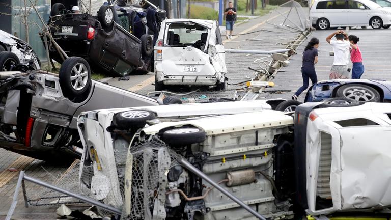 Umgestürzte Autos liegen zerstört auf einer Straße in Japan am 4.9.2018.