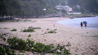 Menschen gehen an einem Strand in Hongkong an Trümmerteilen vorbei, die der Taifun „Noul“ nach seinem Vorbeizug hinterlassen hat.