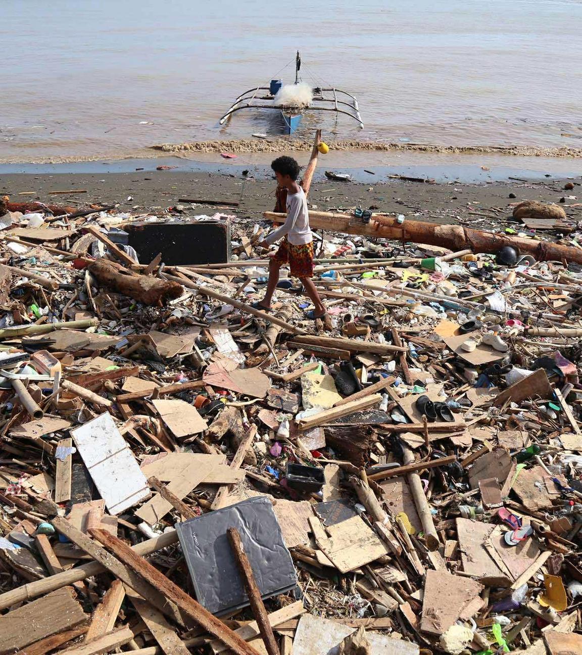 Einwohner gehen an den Trümmern entlang, nachdem der Taifun Kalmaegi in Talisay, Philippinen, Verwüstungen angerichtet hat. 