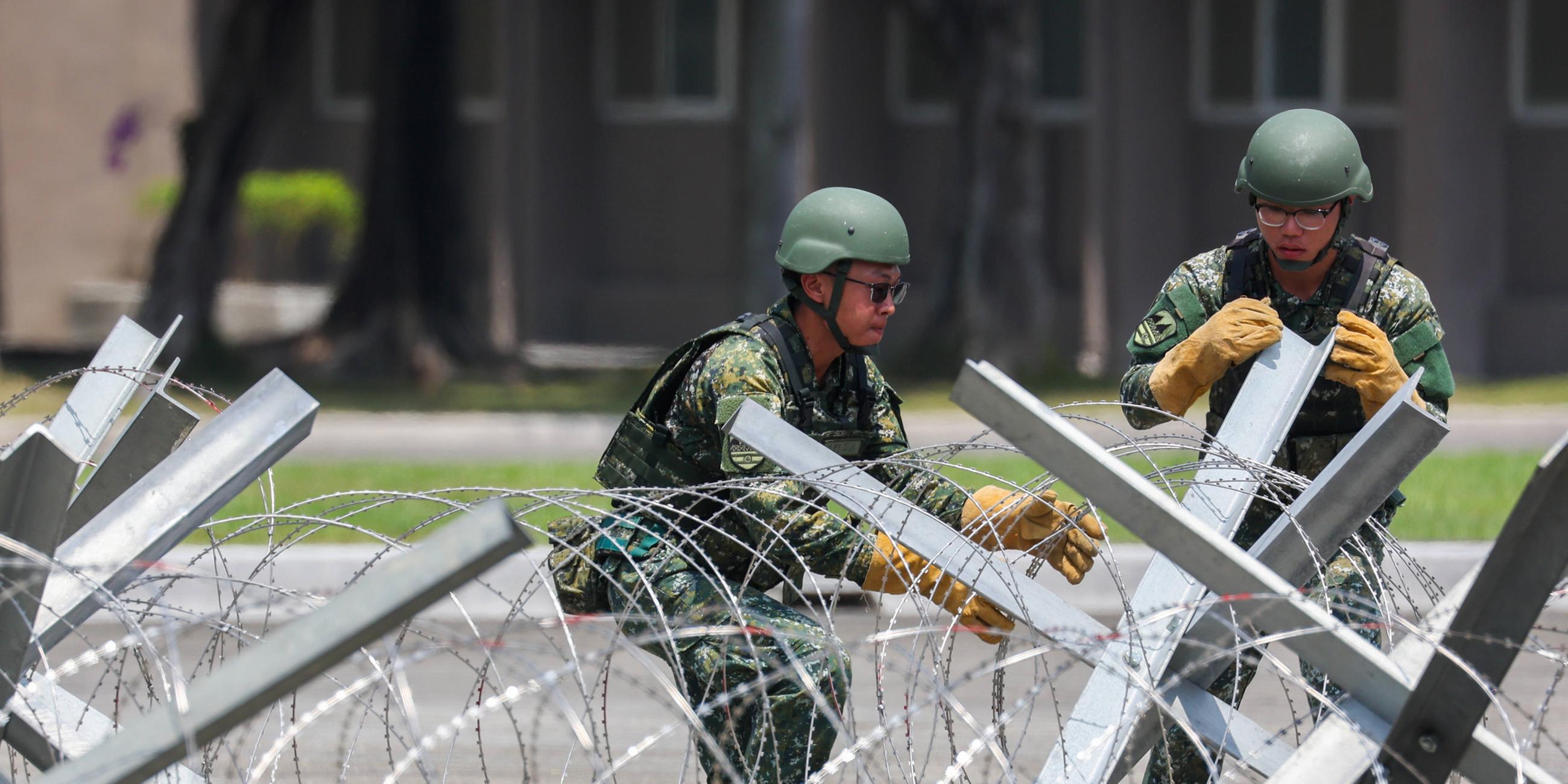 Taiwanesische Soldaten üben das Aufstellen von Sperranlagen bei einem Truppenbesuch von Präsident William Lai (Lai Ching-te) auf einem Militärstützpunkt in Kaohsiung, Taiwan.