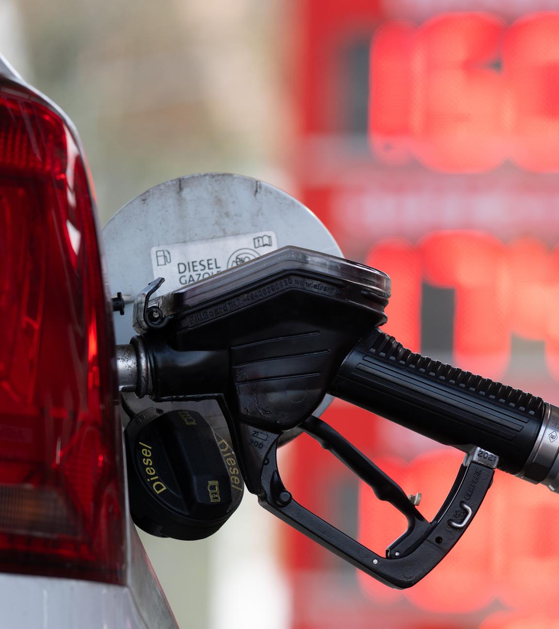 Ein Tankstutzen an einer Tankstelle in der Tanköffnung eines Fahrzeugs, mit der Aufschrift "Diesel".