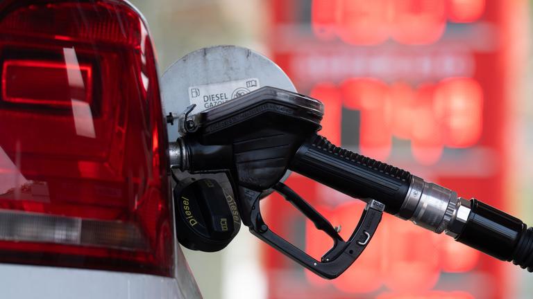 Ein Tankstutzen an einer Tankstelle in der Tanköffnung eines Fahrzeugs, mit der Aufschrift "Diesel".