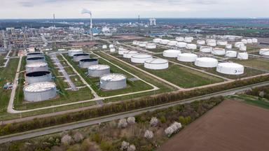 Sachsen-Anhalt, Leuna: Hinter einem Tanklager ragen die Anlagen der Total-Raffinerie und des Chemieparks in die Höhe