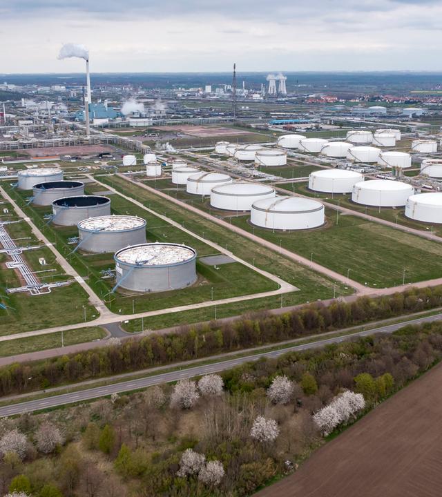 Sachsen-Anhalt, Leuna: Hinter einem Tanklager ragen die Anlagen der Total-Raffinerie und des Chemieparks in die Höhe