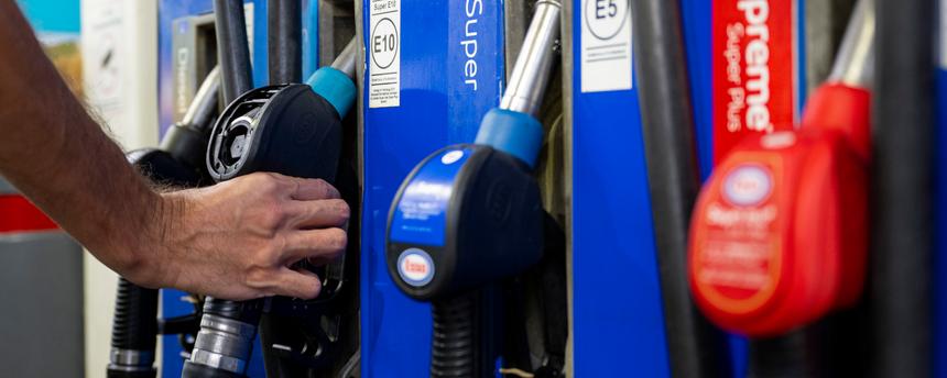 Symbolbild: Ein Autofahrer hängt an einer Tankstelle eine Zapfpistole in die Zapfsäule.