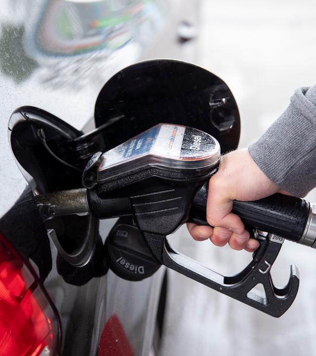 Ein Autofahrer steckt an einer Tankstelle einen Diesel-Zapfhahn in die Tanköffnung seines Fahrzeugs.
