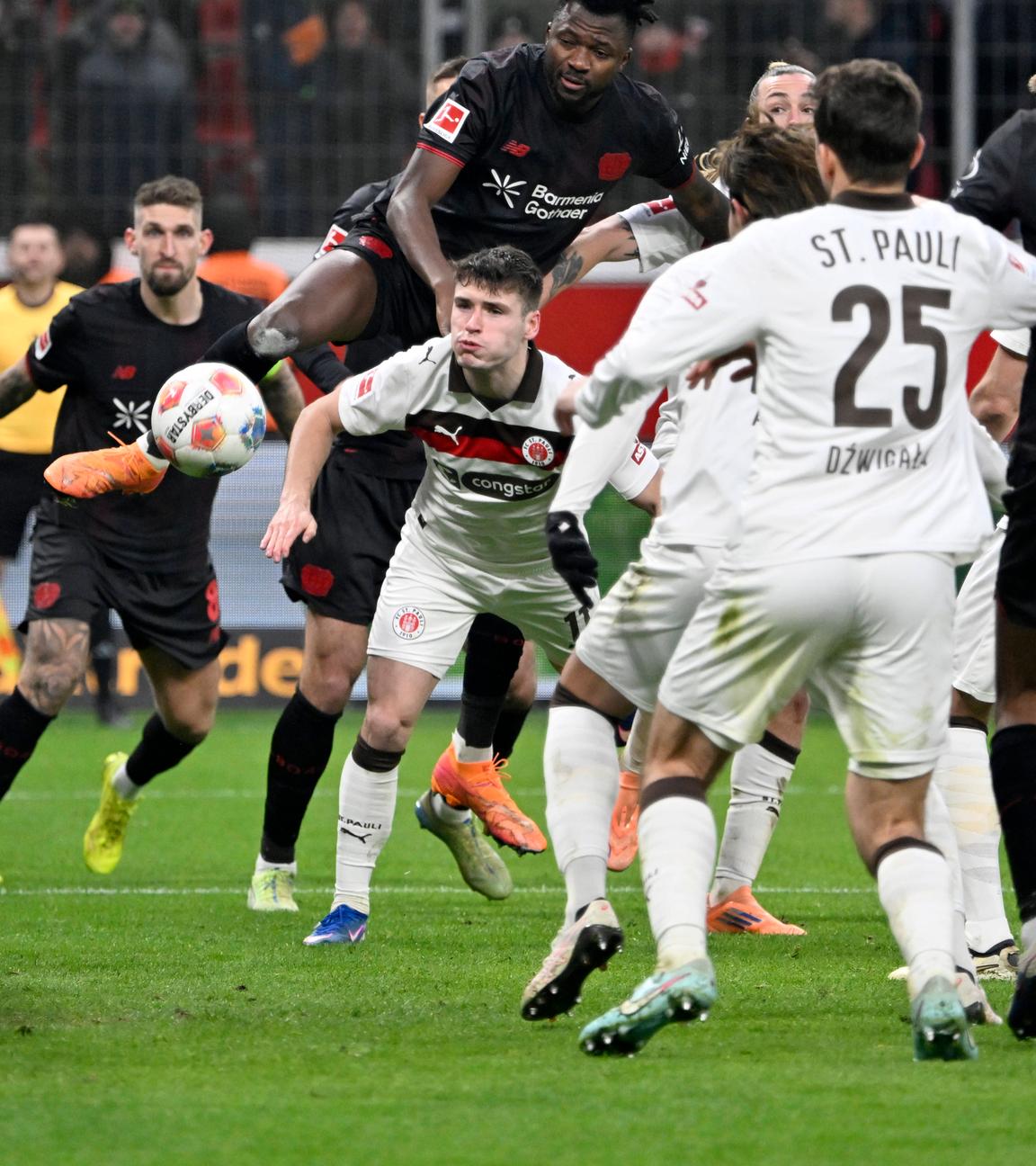 Leverkusens Edmond Tapsoba setzt sich gegen Arkadiusz Pyrka und Jackson Irvine durch und erzielt das Tor zum 3:0 per Kopf