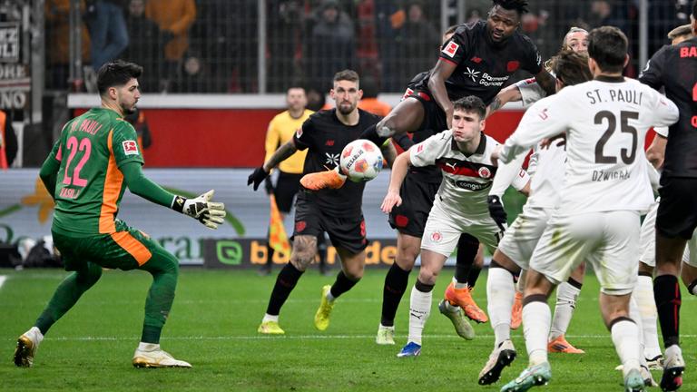 Leverkusens Edmond Tapsoba setzt sich gegen Arkadiusz Pyrka und Jackson Irvine durch und erzielt das Tor zum 3:0 per Kopf