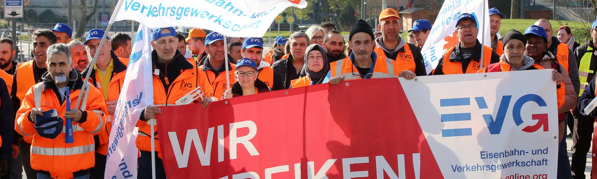 Warnstreikende der Gewerkschaft EVG bei einer Kundgebung in Hamburg halten Fahnen und Banner.