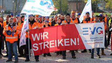Warnstreikende der Gewerkschaft EVG bei einer Kundgebung in Hamburg halten Fahnen und Banner.