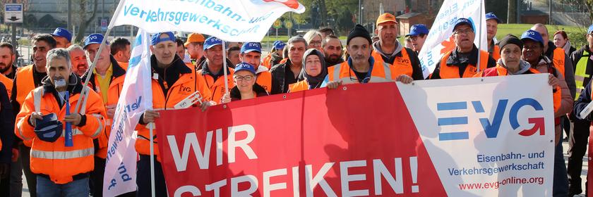 Warnstreikende der Gewerkschaft EVG bei einer Kundgebung in Hamburg halten Fahnen und Banner.