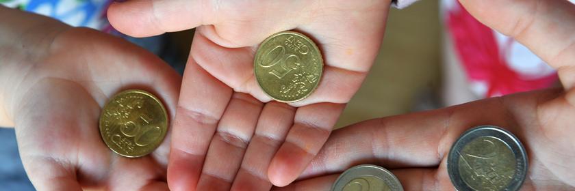 Drei Hände halten Münzen. 