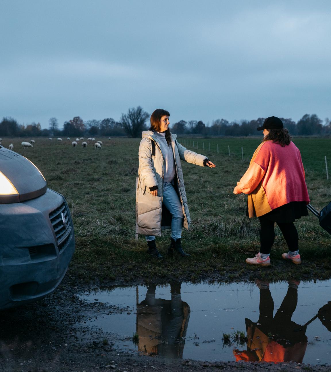 Miriam Peters steht neben ihrem Beratungsbus und reicht einer Frau die Hand.