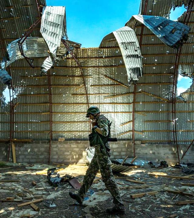 Soldat läuft durch einen zerstörten Hangar