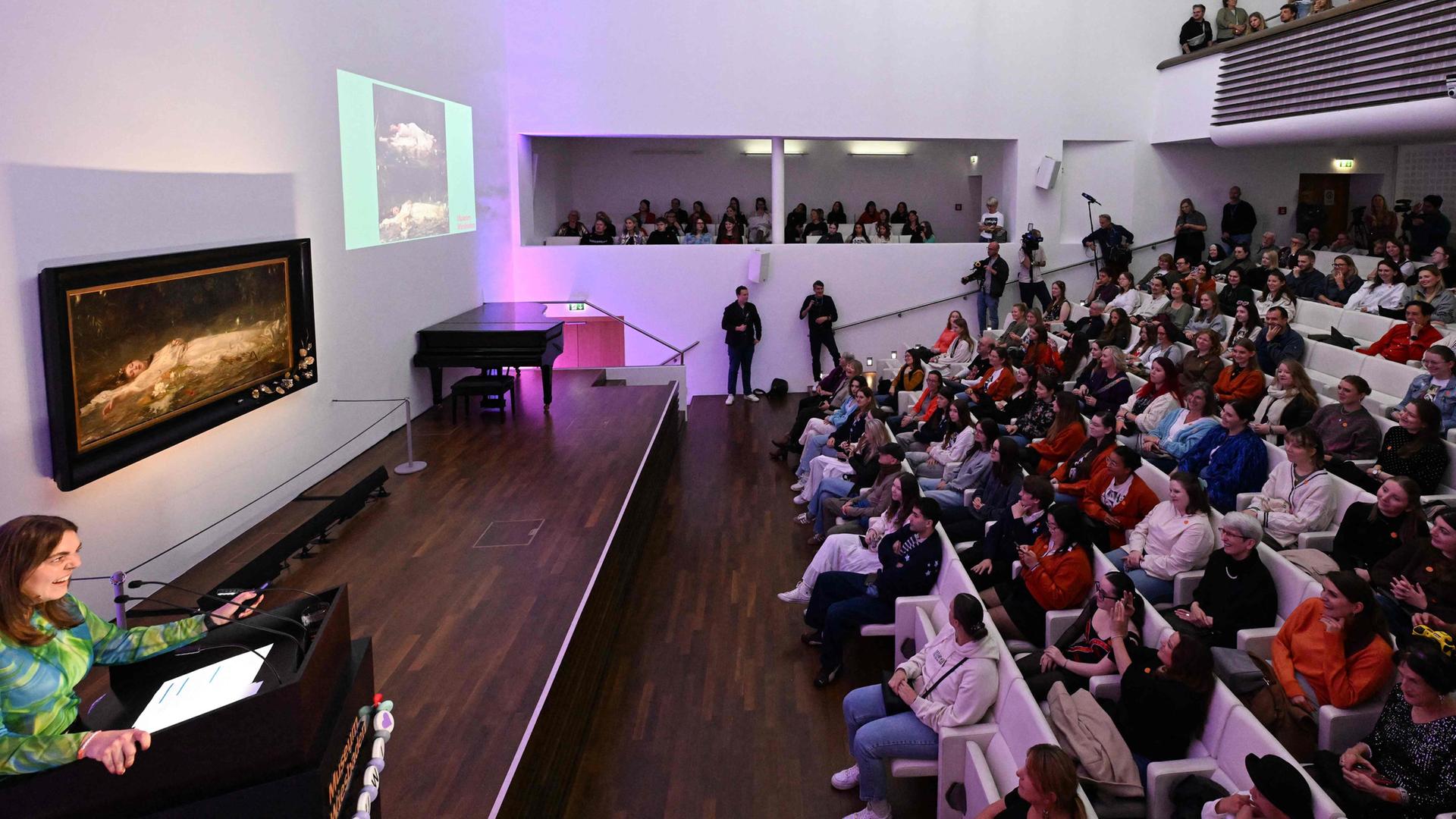 Fans der US-Sängerin Taylor Swift und andere Besucher hören im Museum Wiesbaden während einer kurzen Führung einen Vortrag über das Gemälde „Ophelia“ (um 1900) des deutschen Künstlers Friedrich Heyser.