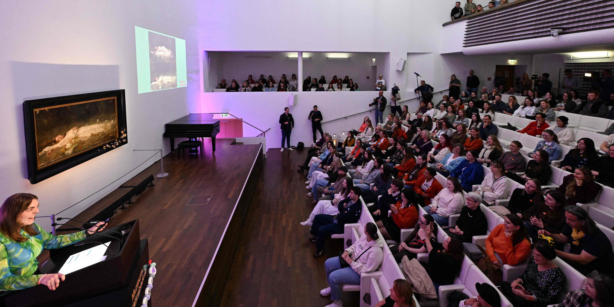 Fans der US-Sängerin Taylor Swift und andere Besucher hören im Museum Wiesbaden während einer kurzen Führung einen Vortrag über das Gemälde „Ophelia“ (um 1900) des deutschen Künstlers Friedrich Heyser.