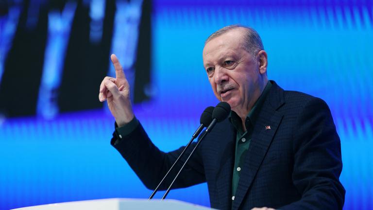 Recep Tayyip Erdogan steht an einem Rednerpult und redet