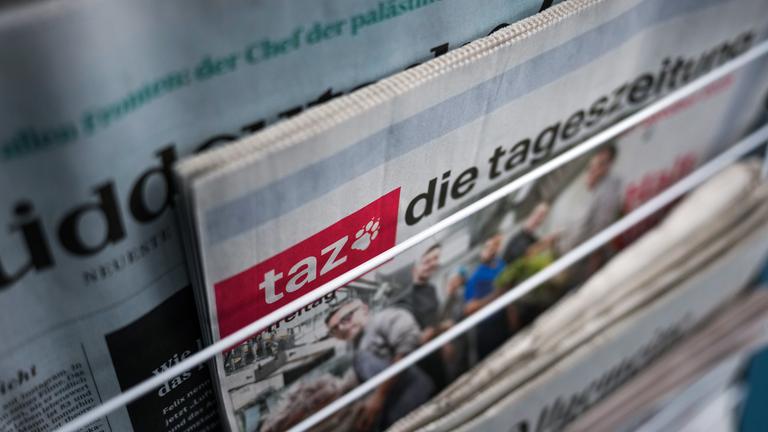 Auf dem Bild sind verschiedene Zeitungen, inlusive die "taz" zu sehen.