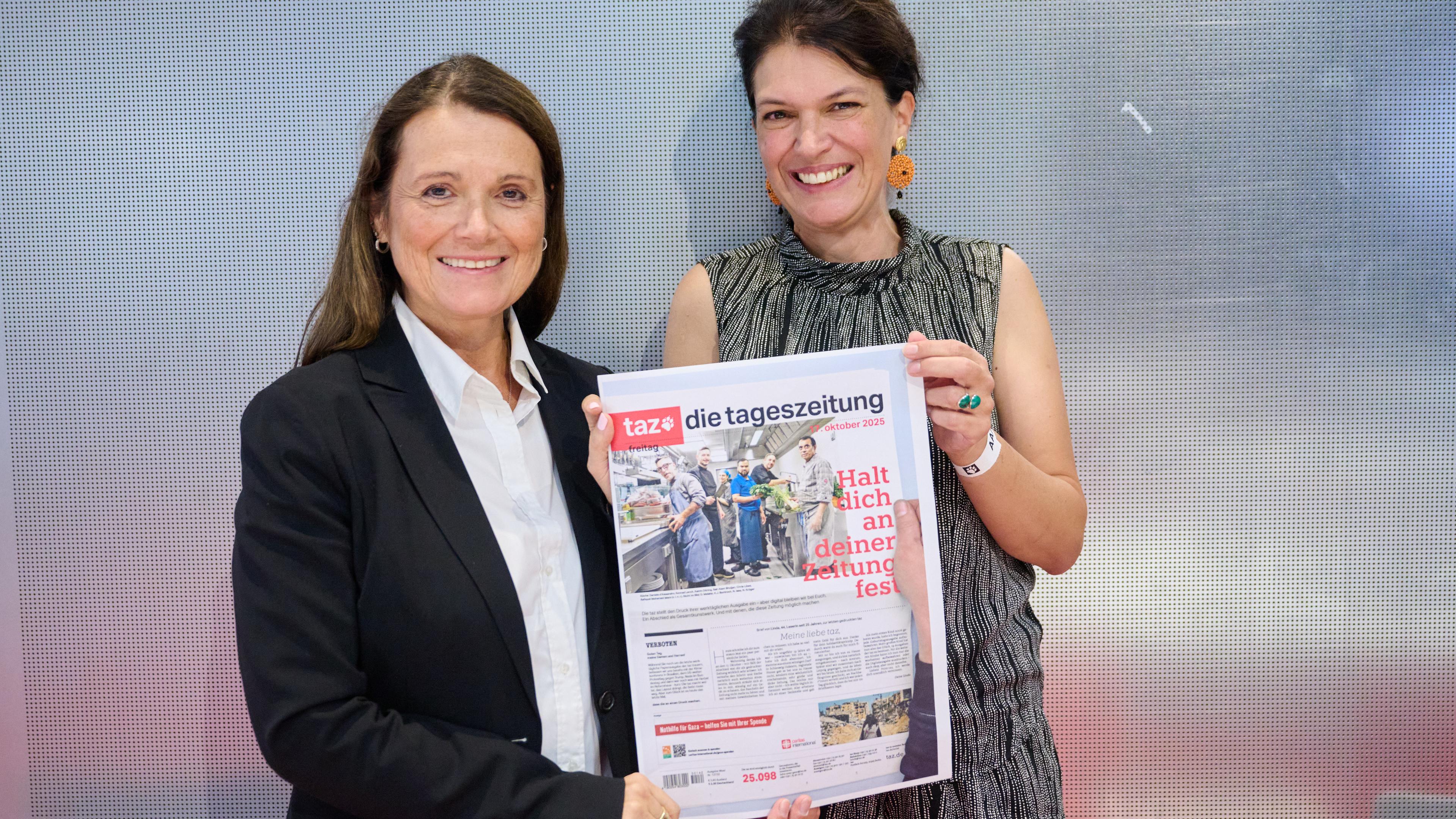 Die beiden Chefredakteurinnen der taz Barbara Junge (l) und Ulrike Winkelmann halten die ausgedruckte Titelseite der letzten werktäglichen Ausgabe der taz in den Händen.