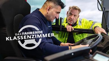Ein Mann sitzt am Steuer eines Linienbusses und schaut auf das Lenkrad. Draußen steht der Fahrlehrer und beugt sich zum Fenster hinein, während er ihm das Buscockpit erklärt. Links unten befindet sich ein weißes Titellogo in Form eines Lenkrads mit dem Schriftzug: „Das fahrende Klassenzimmer“. 