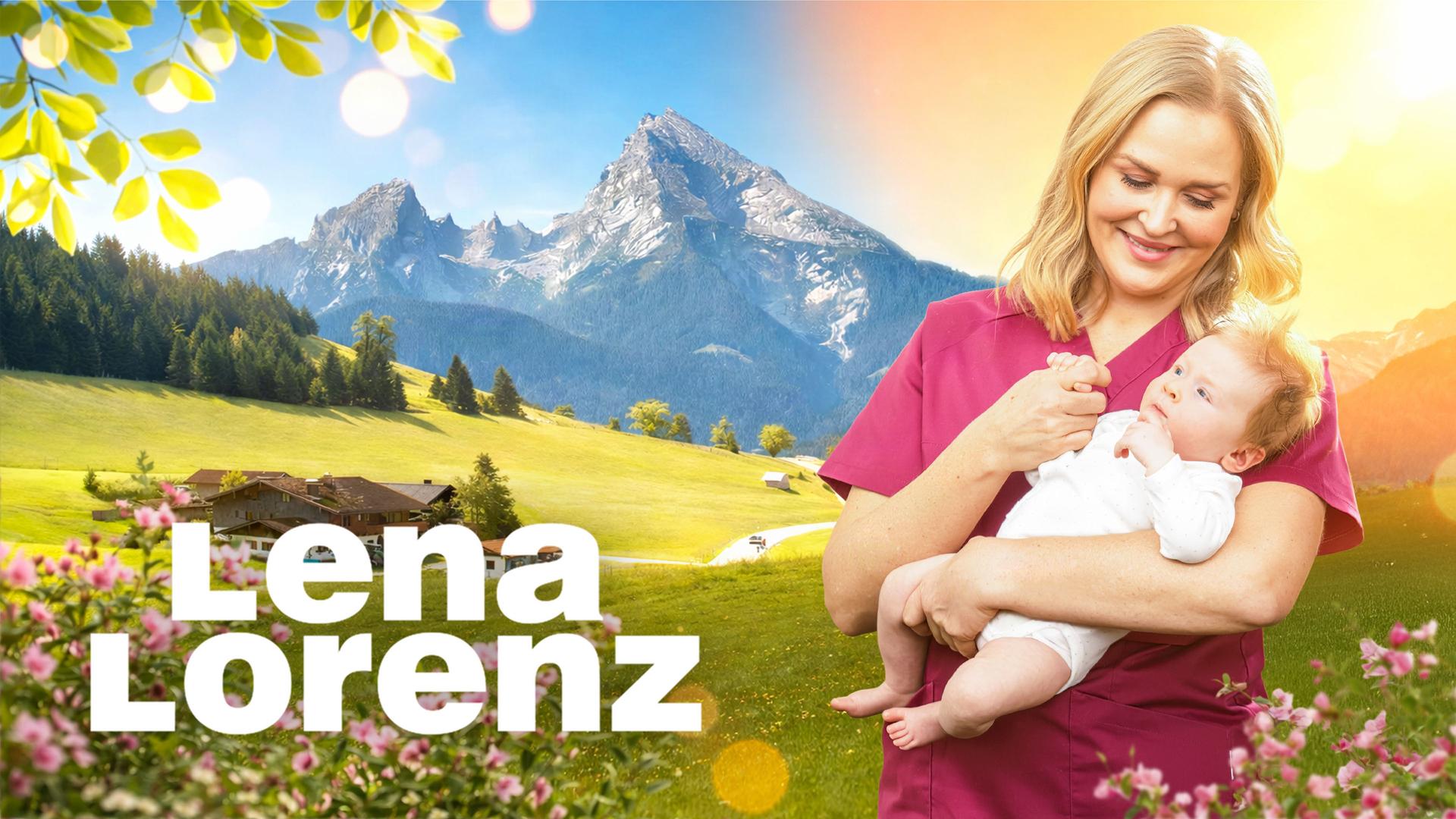 Hebamme Lena Lorenz (Judith Hoersch) steht vor der sonnigen Bergkulisse des Watzmann in den österreichischen Alpen. Sie hält ein Baby im Arm und schaut es liebevoll an.