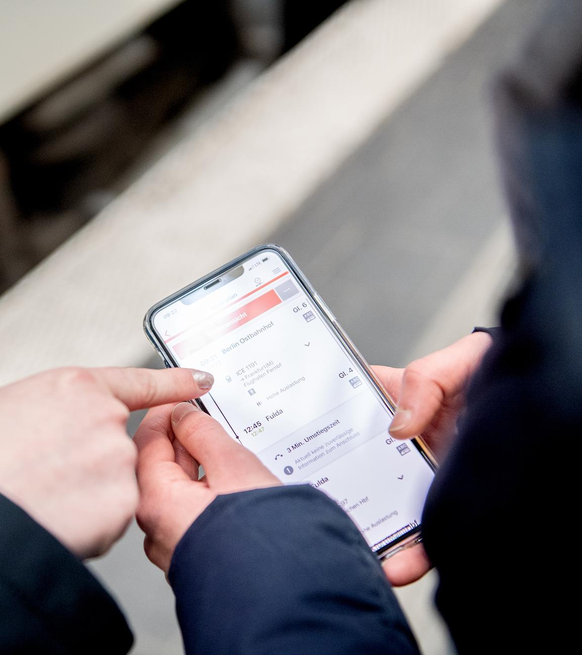 Zwei Personen bedienen die DB-App