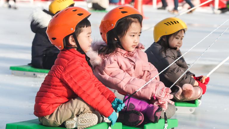 Einige Kinder beim Schlittenfahren