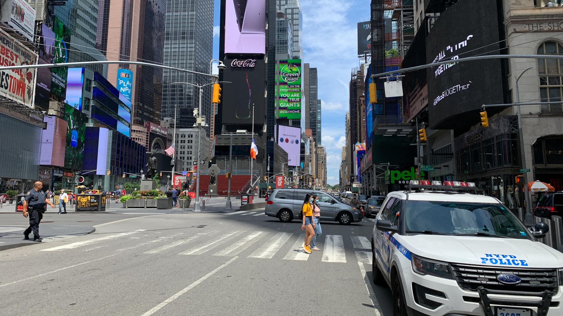 menschen mit mundschutz auf fast leerer strasse vom times square