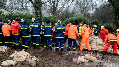 Einsatzkräfte des Technischen Hilfswerks (THW) sind im Einsatz, um ein Wohnhaus am Osternburger Kanal vor dem drohenden Hochwasser mit Sandsäcken zu sichern.